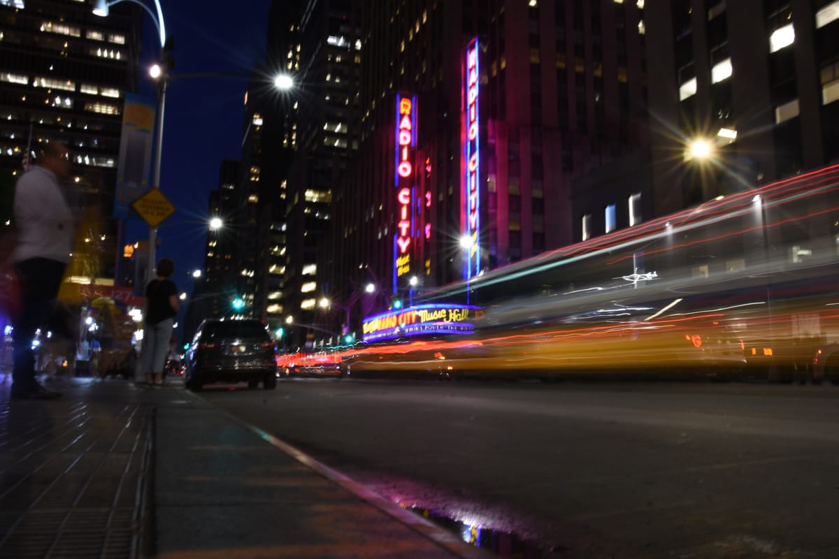 Radio City Music Hall at night with light trails